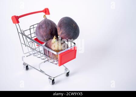 Fresh figs in shopping cart isolated on white. The concept of healthy eating. Stock Photo
