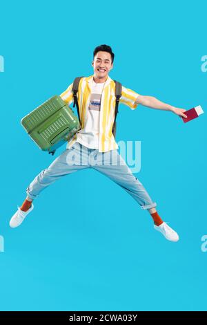 Holding the suitcase bouncing young man Stock Photo