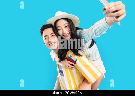 Young man carrying a girlfriend using a mobile phone Stock Photo