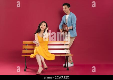 Playing the guitar in the young man and listen to the music of young women Stock Photo