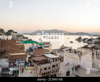 View over the rooftops of Udaipur towards the Taj Lake Palace hotel in Rajasthan, India Stock Photo