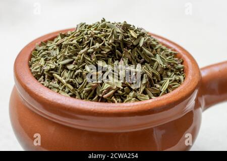 Dried thyme (Thymus) in a earthenware bowl. Stock Photo