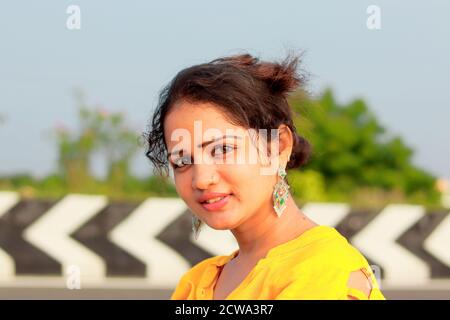Indian cute girl with smiling face. This girl is looking very beautiful.  She is wearing red cloth and a red spot on her head Stock Photo - Alamy