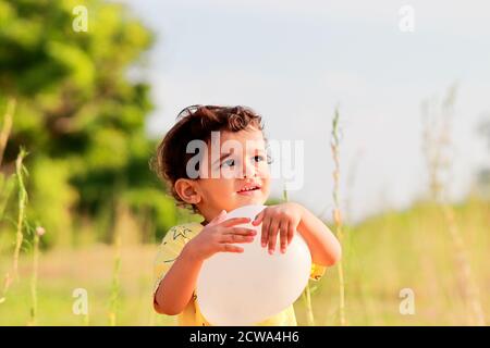 asian child playing outdoors with balloon Stock Photo
