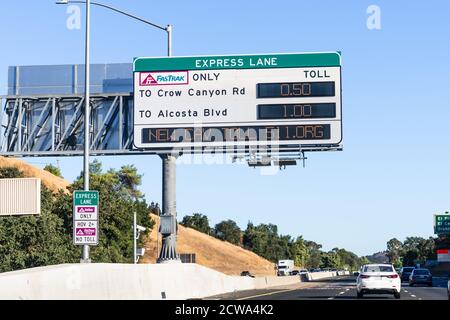 Sep 23, 2020 San Ramon / CA / USA - Freeway Express Lane sign displaying the next exits and the applicable fees, plus a message about the new CAV (Cle Stock Photo