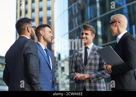 Successful business team talking to each other they discussing new plans during meeting in the city Stock Photo