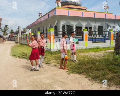 Pasar Kecamatan Pasanea, Indonesia - Feb 15, 2018: Schoolchildren in the uniform before Mosque - Masjid Darussalam in the small village on Seram Islan Stock Photo