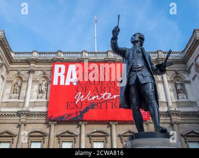 Statue of Sir Joshua Reynolds wearing Covid-19 facemask outside The Royal Academy of Arts at the opening of The 2020 RA Summer Winter Exhibition. Stock Photo