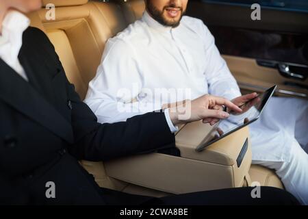 Close-up of business people using digital tablet in team during driving in the car Stock Photo