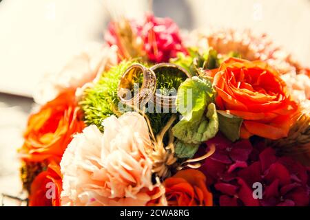 Wedding rings on the bride's bouquet in the autumn theme. Stock Photo