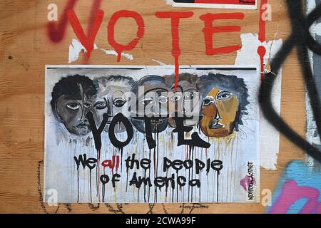 New York City, USA. 28th Sep, 2020. A poster depicting people of different races is plastered under the painted word “vote” on a boarded up store in the Soho neighborhood of New York, NY, September 28, 2020. With little more than a month before the United States Presidential elections, comments in the form of posters, signs and drawings are seen throughout the city, where New York is considered a “blue” democratic State. (Anthony Behar/Sipa USA) Credit: Sipa USA/Alamy Live News Stock Photo