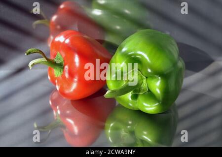 Green and red peppers on a stainless steel surface. Stock Photo