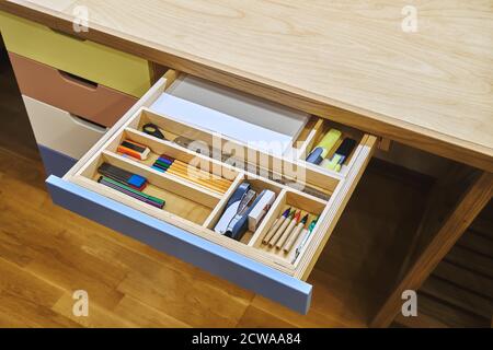 Ready for school. Open desk drawer with various school supplies arranged carefully in order before studies Stock Photo