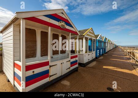 A row of colourful beach huts on the seafront at Southwold on a summers day on the Suffolk Coast. Stock Photo