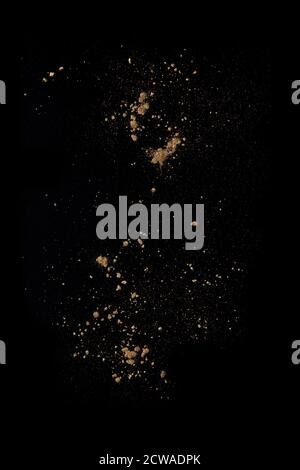 Golden powders splash and dust over black. Abstract design background Stock Photo