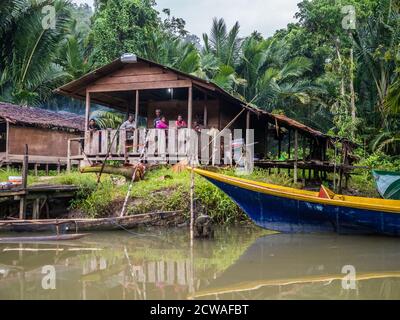 Kensi, Arguni,  Indonesia - February 06, 2018:  Papuan people in a wooden house on the river bank. Bird's Head Peninsula, West Papua, Indonesia, Asia. Stock Photo