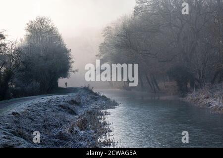 Man out for morning run along a canal on a frosty winter morning Stock Photo