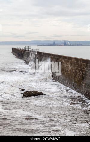View of stormy seas at Hartlepool Headland with Industrial Teesside in background Stock Photo