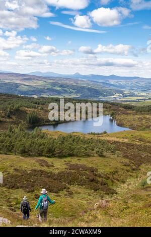 Two walkers heading off Deuchary Hill towards Loch na Benne, Perth and Kinross, Scotland. Stock Photo