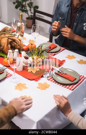 People sitting at table served for Thanksgiving dinner, close up view ...