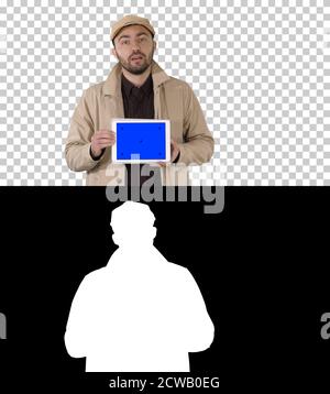 Man in trench walking and holding tablet with blue screen mockup Stock Photo