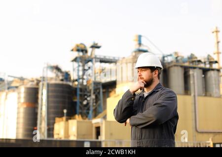 Portrait of thoughtful industrial director standing near factory outside. Stock Photo