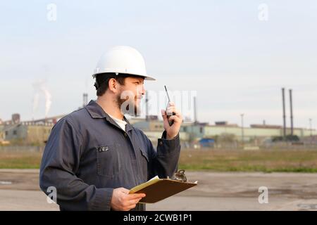 Portrait of builder engineer standing on construction site and holding papers. Stock Photo