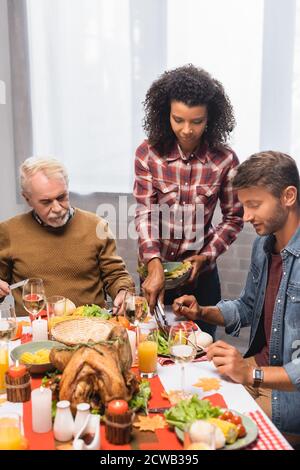 african american woman serving food on plate of man on thanksgiving Stock Photo