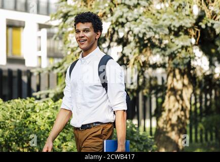 Young smiling male student with notebook going to college Stock Photo