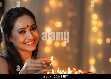Woman smiling with a diya in her hand Stock Photo