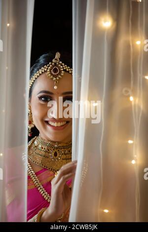 Beautiful bride smiling from the curtain Stock Photo