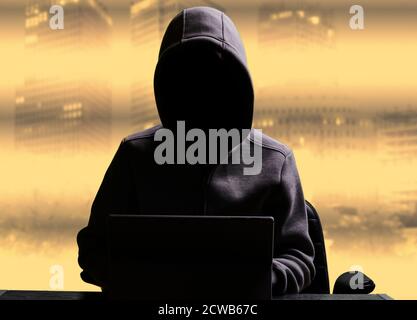 Computer hacker with hoodie behind his computer Stock Photo