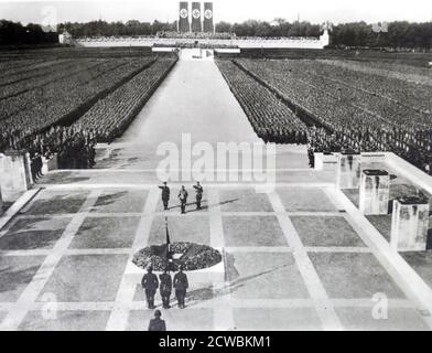 Black and white photo of an enormous demonstration at the Nuremberg Stadium attended by 1000s of people. Hitler, Himmler and Lutze are at the centre. Stock Photo