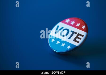 closeup of a vote badge for the United States election on a dark blue background, with some blank space on the left Stock Photo