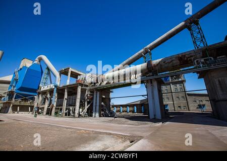 Mynaral/Kazakhstan - April 23 2012: Modern Jambyl Cement plant. Clinker (cement) rotary clinker kiln, belt conveyor and factory buildings. Panorama vi Stock Photo