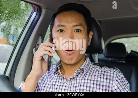 man in a scotch shirt with a shocked look on the phone Stock Photo