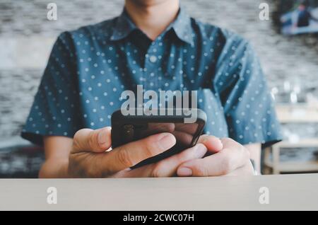 man using mobile smart phone in coffee shop. Stock Photo