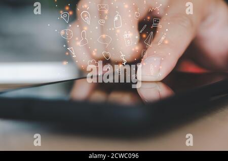 Hand holding  smartphone with icons concept. Stock Photo
