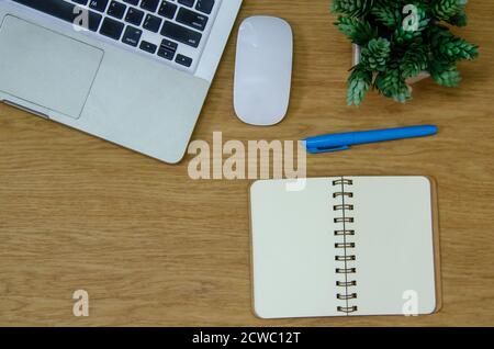 Top view laptop computer , mouse , flower , notepad and pen on wood table.Flat lay  copy spce.work for home Stock Photo
