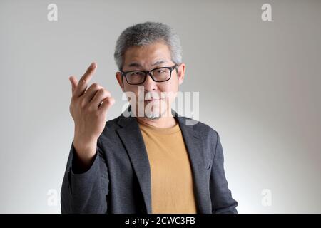 The Asian man in smart casual standing on the white background. Stock Photo