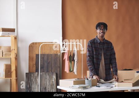 Portrait of young African man smiling at camera while working in delivery service Stock Photo