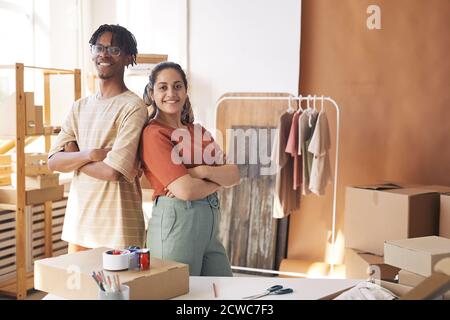Portrait of two workers standing with arms crossed and smiling at camera they working in delivery service with parcels Stock Photo