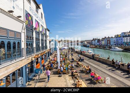 Outdoor dining at the Anchor Rendezvous pub in Weymouth, a seaside town holiday resort on the estuary of the River Wey, Dorset, south coast England Stock Photo