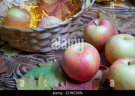 Beautiful autumn background.maple leaves on a wooden background.Apples in the basket Stock Photo