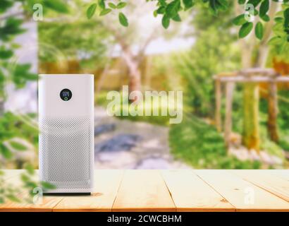 Air Purifier on the wood table at graden.  Air purification from viruses and bacteria Stock Photo