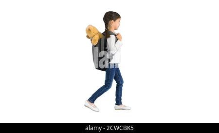 Cute little girl walking to school with a teddy bear sticking ou Stock Photo