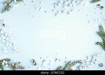 Christmas frame with fir branches and decorations on blue background. Flat lay, New Year border. Stock Photo