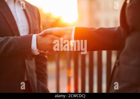 Close-up of business people in formal suits shaking hands to each other during meeting standing at balcony Stock Photo