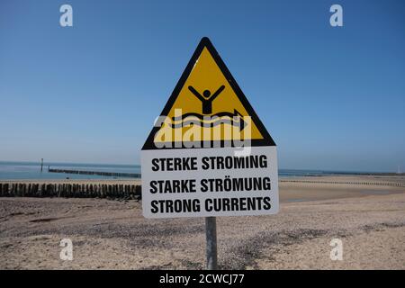 Strong current sign on beach with blue sea in the background Stock Photo
