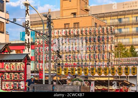 akihabara, japan - november 08 2019: Shinto Ootori shrine decorated with paper lanterns during Tori-no-Ichi Fair with men putting in a garbage old aus Stock Photo